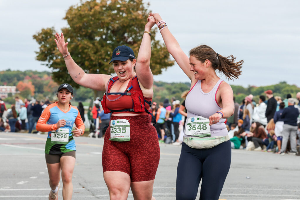 Two runners celebrate as they approach the finish line