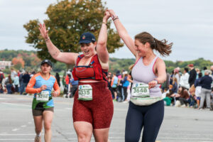 Two runners celebrate as they approach the finish line