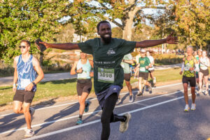 Runner poses with arms outstretched for photo on the race course