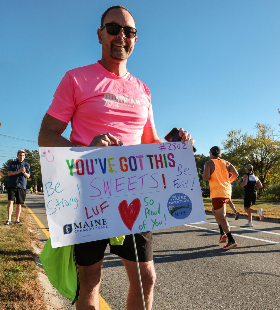 Supportive spectator with sign that  says, "You've got this sweets"
